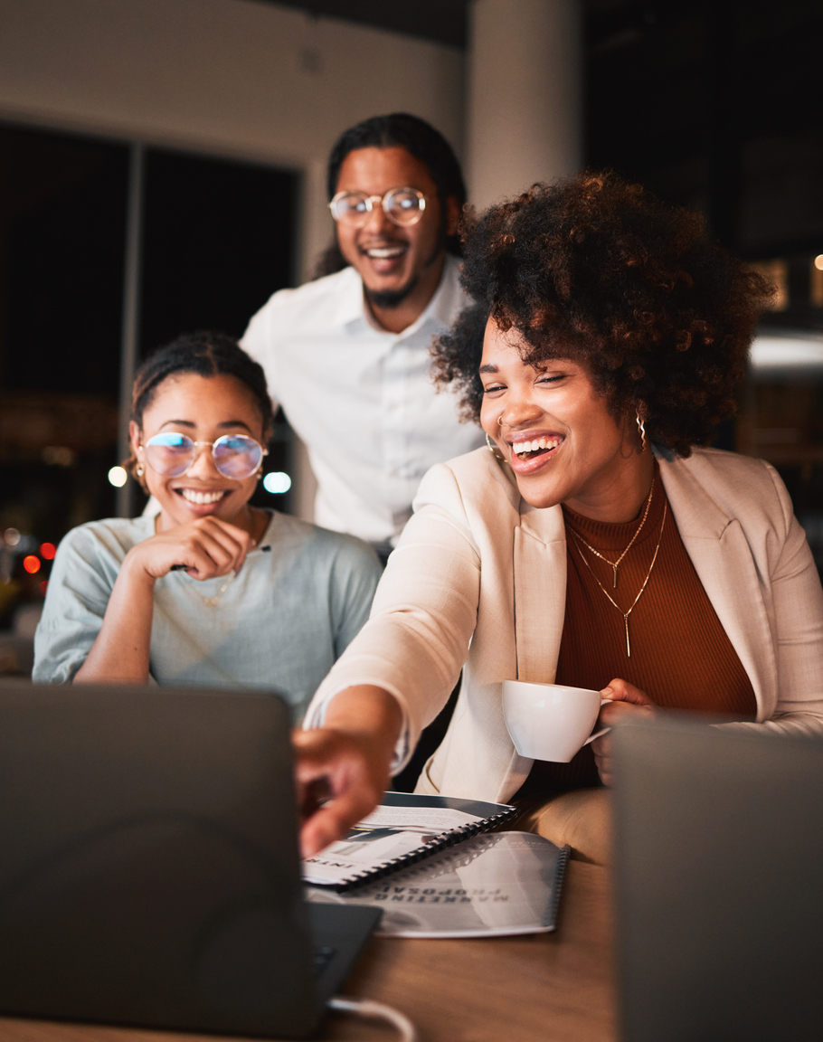 Happy, technology and professional designers working overtime in collaboration on a computer in workplace